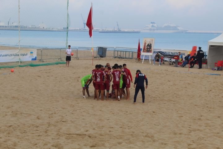 une équipe de football de plage réunie en cercle pour un moment de concentration ou de motivation avant le début du match photo gratuite