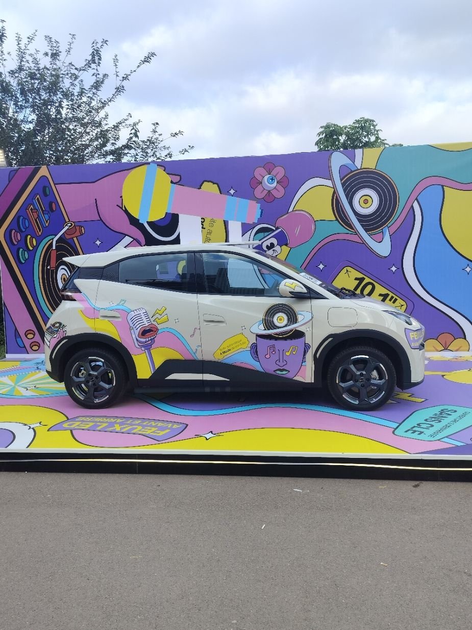 Une BYD Seagull, une petite citadine électrique, devant un mur plein de graffiti, photo gratuite
