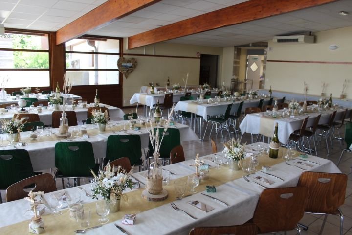 Une salle de réception décorée pour un événement, les tables sont dressées avec des nappes blanches et des bouteilles de vin, photo gratuite