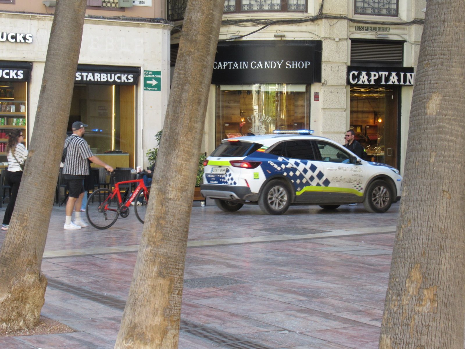 Une voiture de police se trouve garée devant le magasin de confiseries, photo gratuite