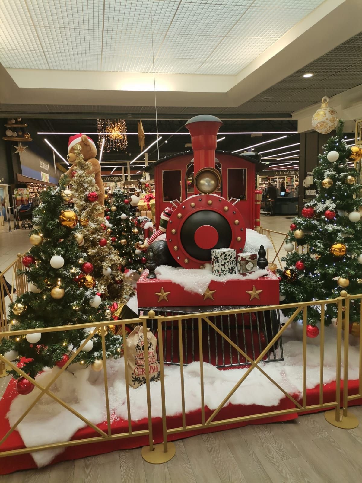 Sapins et train de Noël décorant l'intérieur d'un centre commercial