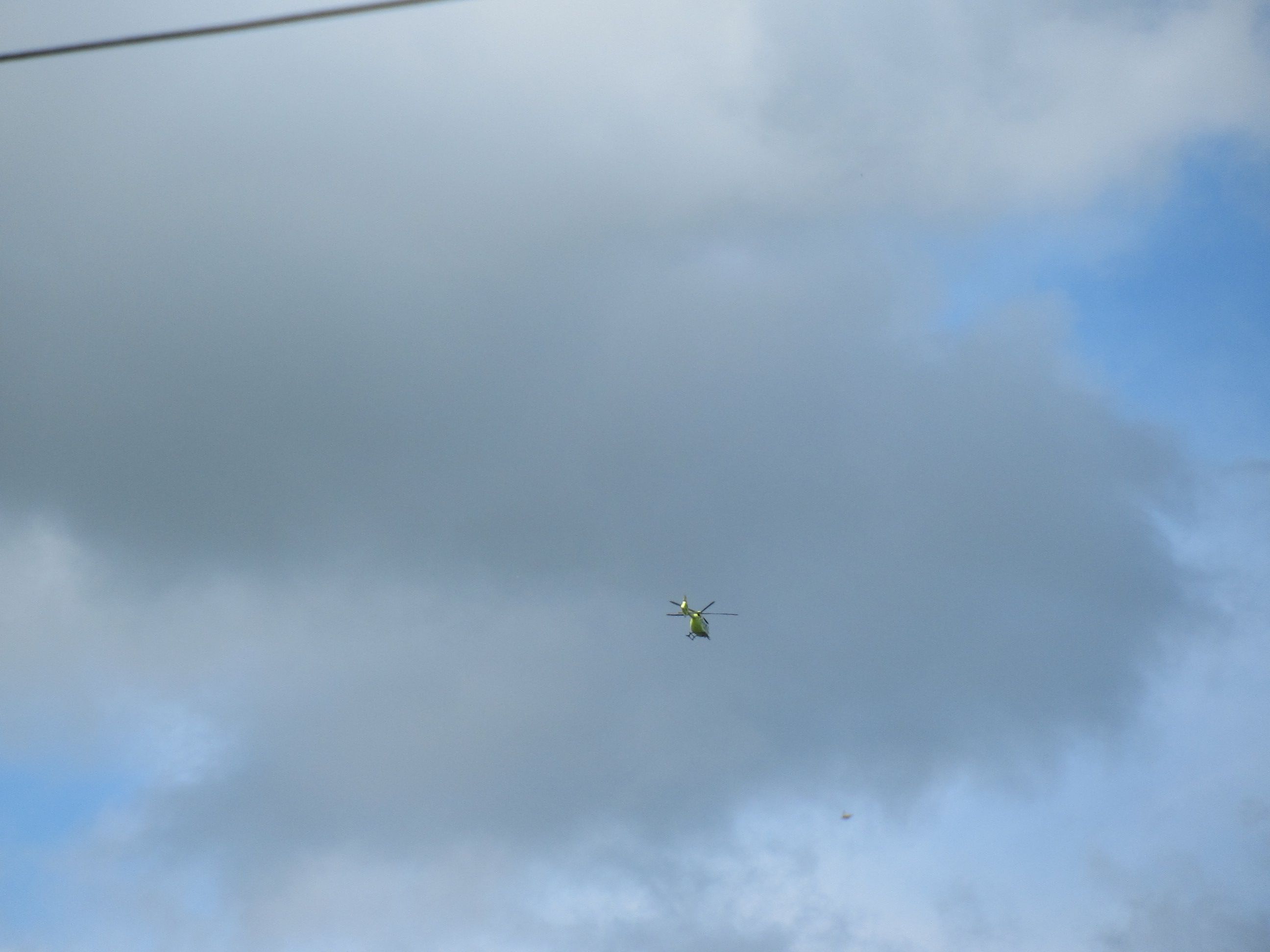 Hélicoptère au dessus de nuages gris dans le ciel