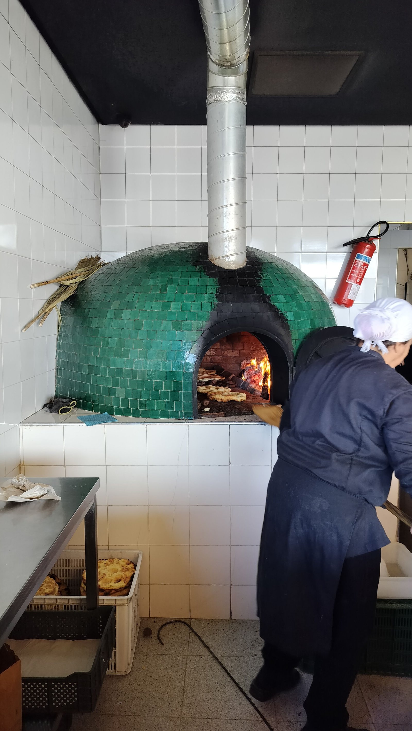 Personne préparant du pain ou de la pizza dans un grand four, photo gratuite