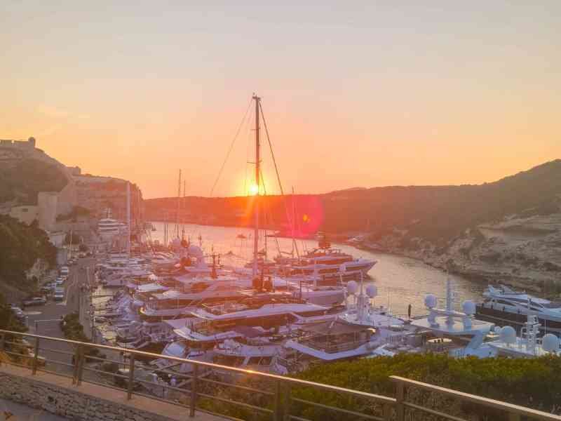 Soleil couchant à l'horizon au port de Bonifacio en Corse, France, photo gratuite