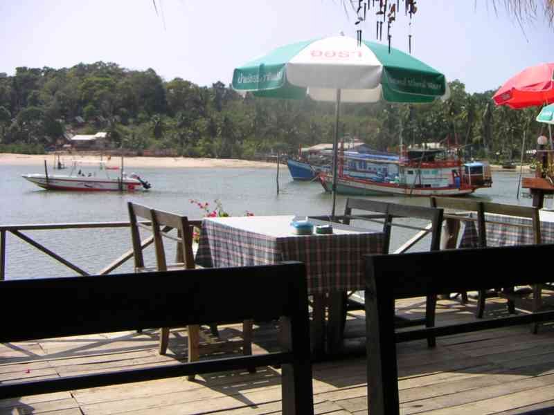 Un restaurant en bord de mer, situé en Thaïlande, avec une vue sur l'eau et des bateaux, photo gratuite
