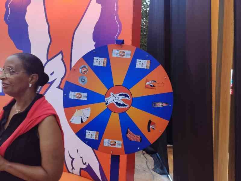 Une femme devant une roue de la fortune, un jeu de hasard où les participants font tourner une roue pour gagner des prix, photo gratuite