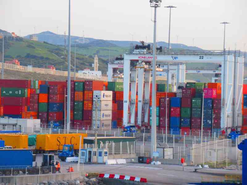 Plusieurs conteneurs empilés près d'un port