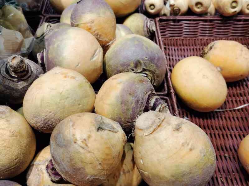 Légumes rutabaga en vente dans un panier du marché photo gratuite