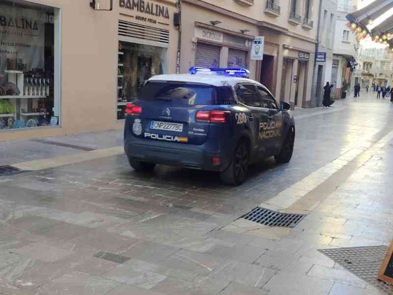 Une voiture de police garée dans une rue étroite devant un magasin, photo gratuite