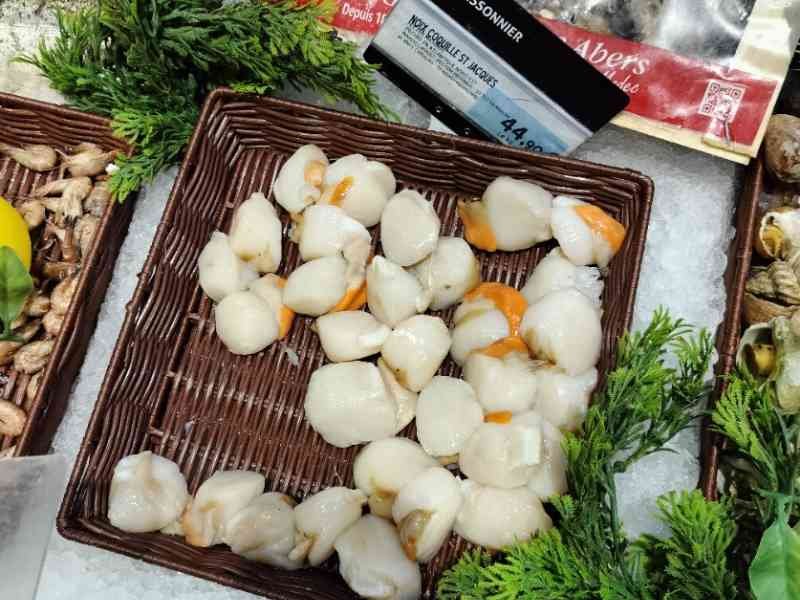 Noix de Saint Jacques coraillées en vente dans un marché photo gratuite