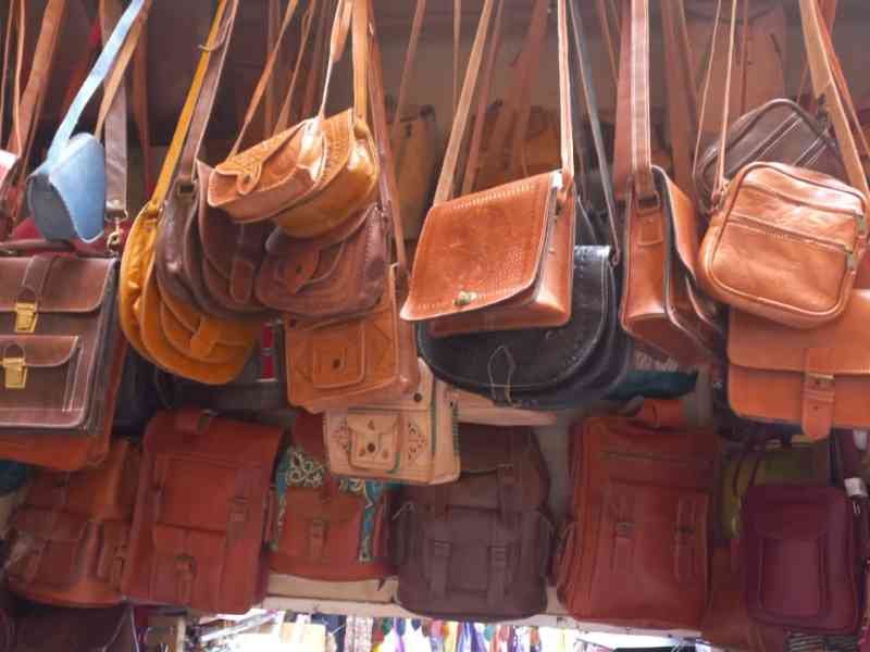 Collection de sacs en cuir accrochés sur un stand de marché photo gratuite - Sammlung von Ledertaschen, die an einem Marktstand hängen, kostenloses Foto