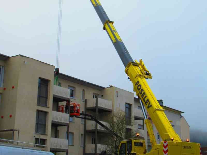 Grue automotrice routière, levage d'objet dans un bâtiment en étage photo gratuite - Selbstfahrender Straßenkran zum Heben eines Objekts in einem mehrstöckigen Gebäude, kostenlose Fotos
