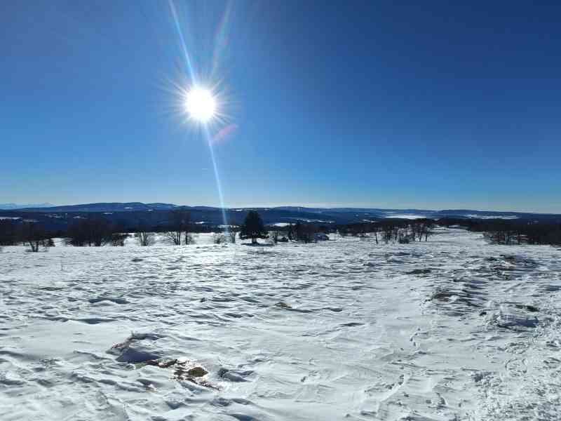 Un paysage de montagne enneigé sous un ciel bleu et ensoleillé, photo gratuite