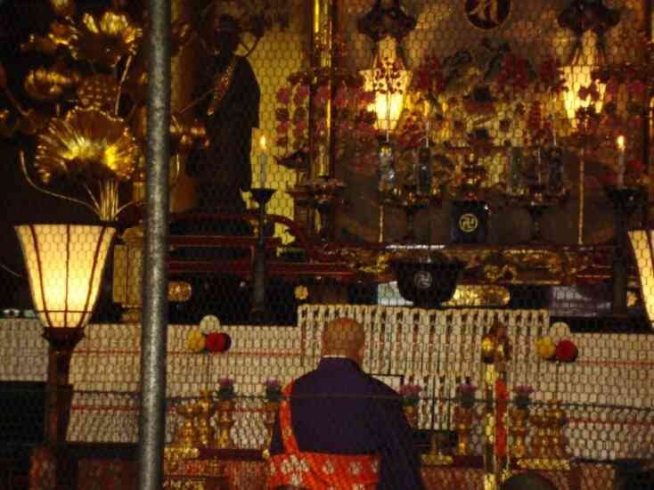Moine en prière dans un temple bouddhiste photo gratuite