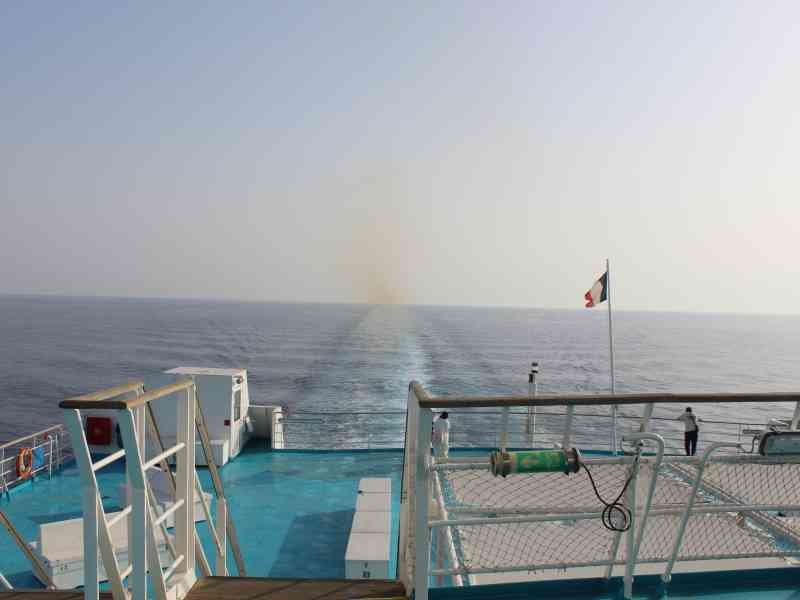 La poupe d'un navire en mer. On peut voir le sillage du navire s'étendant à l'arrière, ainsi qu'un drapeau français flottant, photo gratuite