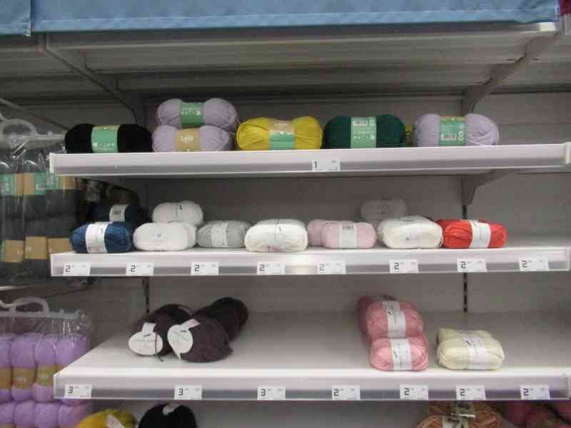 Pelotes de laines multicolores sur les rayons d'un magasin