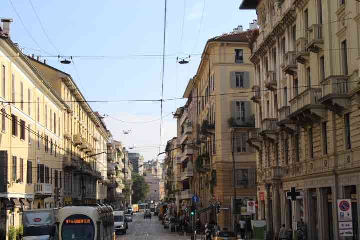 Une rue animée de Milan avec des bâtiments de style architectural européen, des tramways et des lignes aériennes électriques, photo gratuite