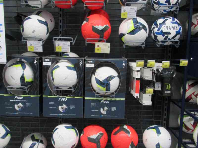 Rangées de ballons de football dans un magasin de sport