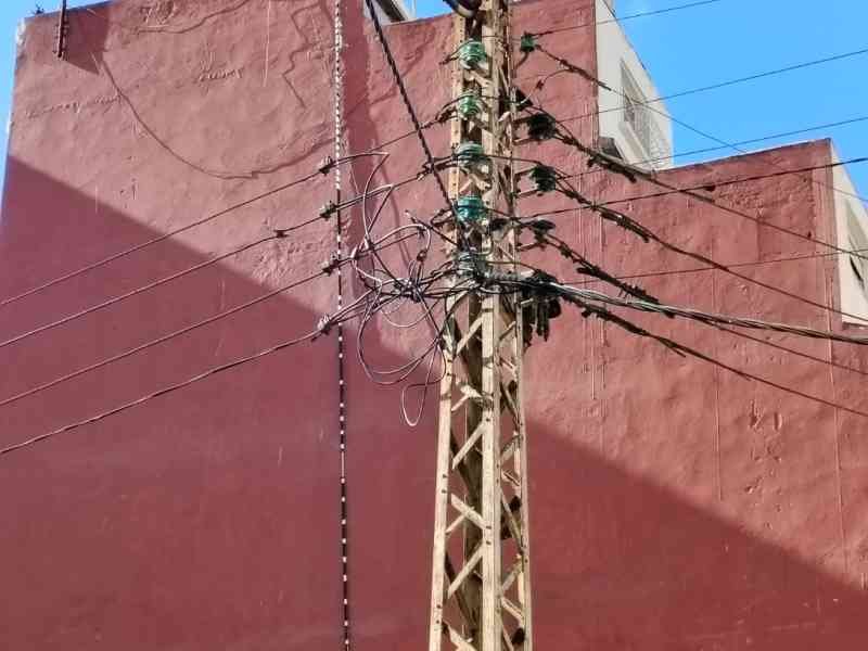 Un poteau électrique en treillis métallique transportant de multiples câbles et fils, photo gratuite