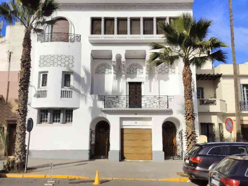 Façade d'un bâtiment blanc, en étage, à quelques mètres du goudron dans la ville de Casablanca au Maroc photo gratuite