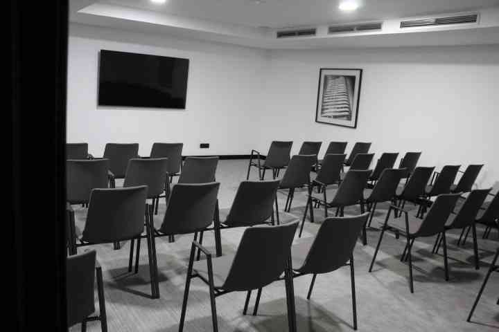 Salle de réunion vide avec un écran et des chaises photo gratuite