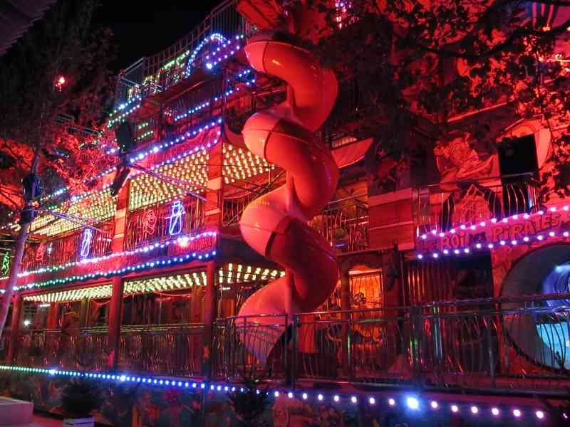 Edifice lumineux entourée de branche d'arbre, foire, fête foraine photo gratuite