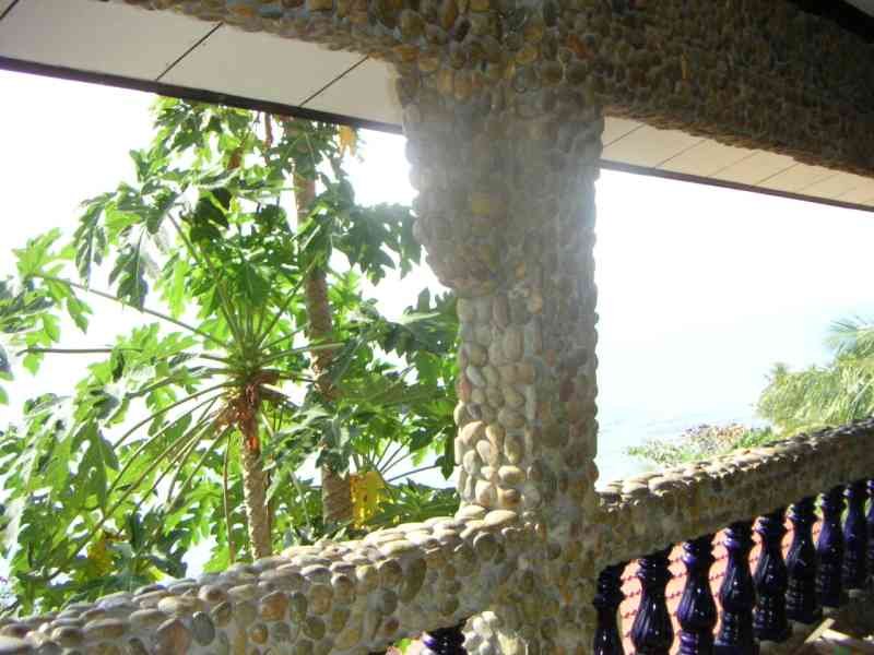 Un balcon ou une terrasse avec une balustrade et un pilier recouverts de galets ou de petites pierres, photo gratuite