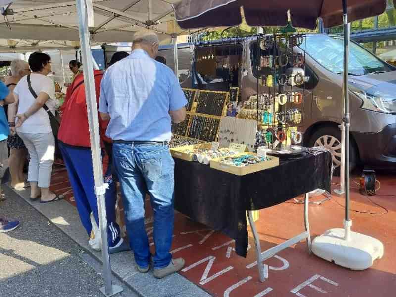 Un étal de marché vendant des bijoux et accessoires, personnes regardent les articles, photo gratuite