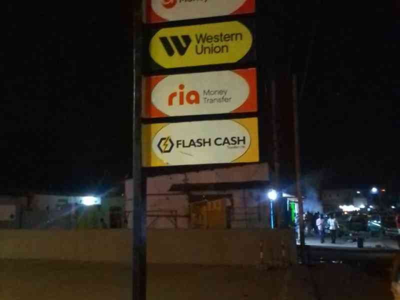 panneau publicitaire indiquant une agence de transfert des fonds via Western Union, Moneygram, Ria et Flash cash photo gratuite