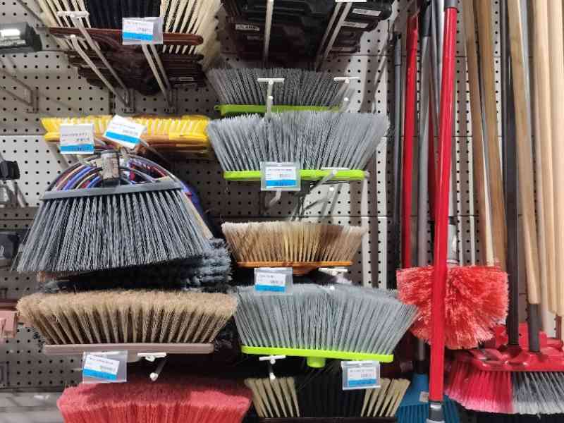 Un assortiment de balais disposés sur un présentoir de magasin, photo gratuite