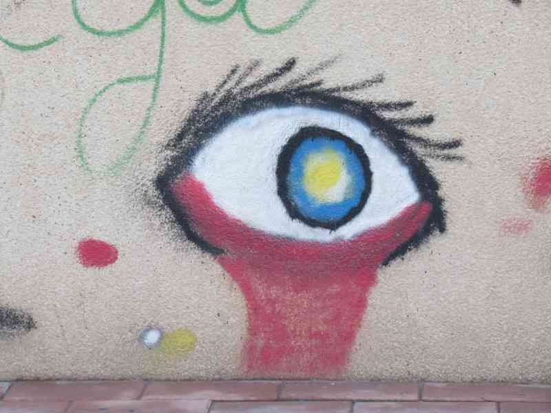 Un graffiti représentant un œil larmoyant sur un mur texturé, photo gratuite
