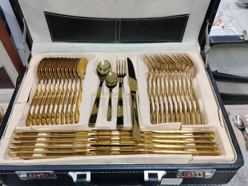 Un coffret de couverts de table, spécifiquement un ensemble de couverts plaqués or, photo gratuite