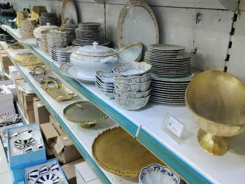 Un rayon de magasin vendant de la vaisselle et des articles de table, incluant des assiettes, des bols, des tasses, photo gratuite