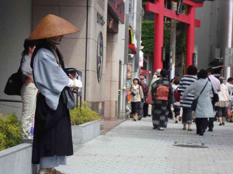 Passants en tenue traditionnelle du Japon devant un Torii rouge photo gratuite