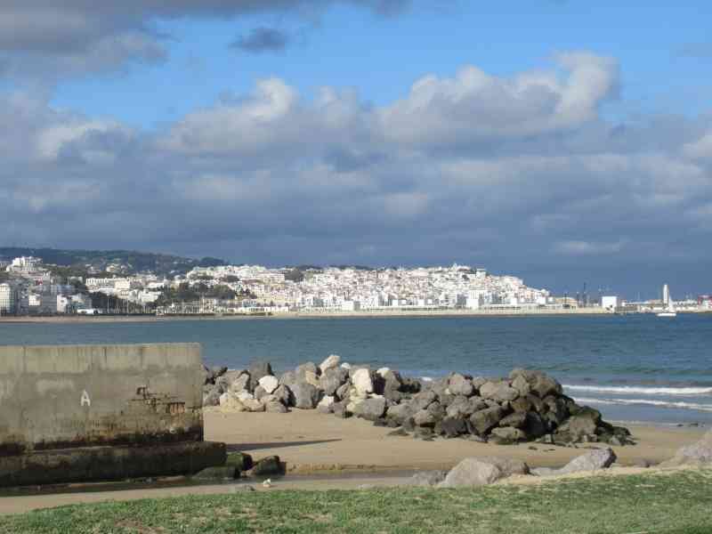 Vue de la ville de Tanger depuis la plage, morceaux de pierres à la plage photo gratuite