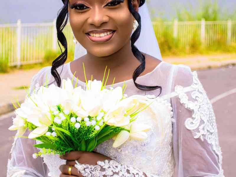 Portrait de mariée souriante en robe blanche avec couronne dorée et bouquet de fleurs blanches photo gratuite photo gratuite