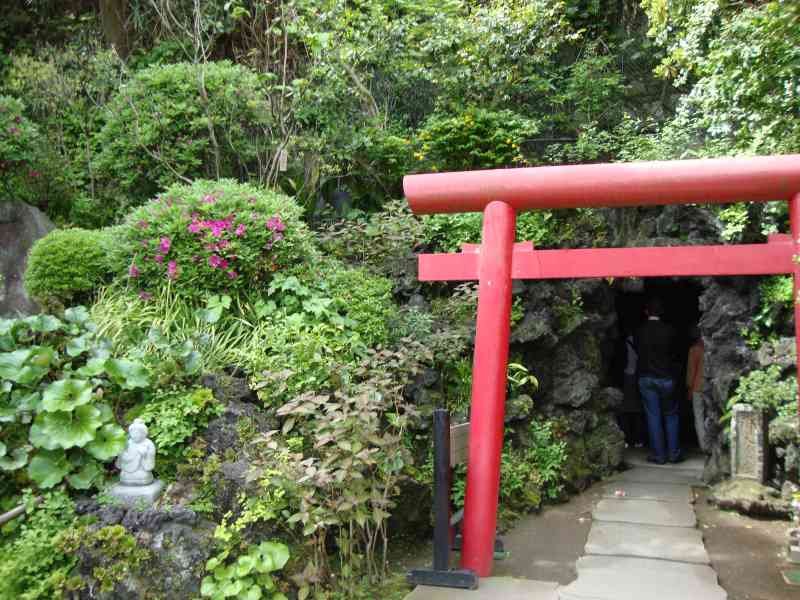Portail traditionnel japonais à l'entrée d'une grotte entourée de verdure photo gratuite