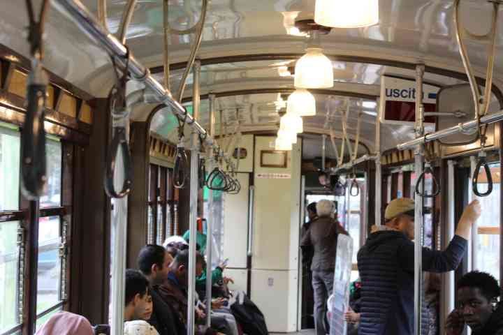Personnes au bord d'un tramway, transport commun, en déplacement dans la ville de Milan Lombardie en Italie photo gratuite