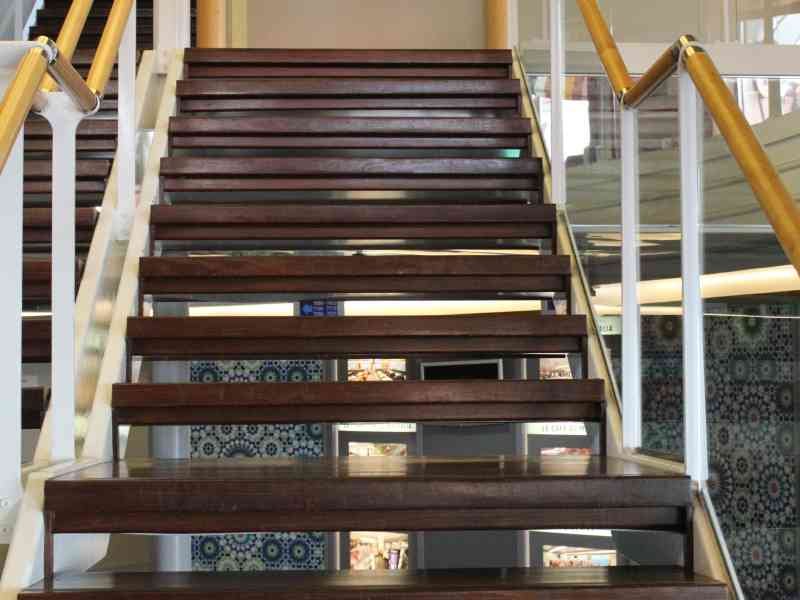 Un escalier intérieur, à bord d'un navire, avec des marches en bois et des rampes en bois et métal, photo gratuite