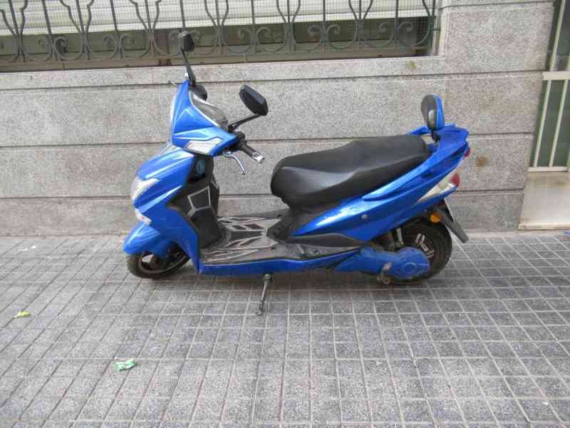 Scooter électrique Sunra Hawk garé sur un trottoir photo gratuite