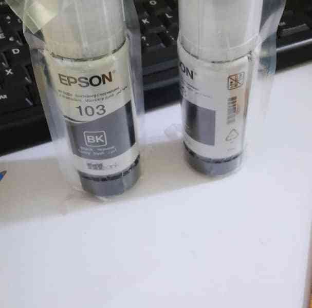 Bouteilles d’encre noire Epson en emballage photo gratuite