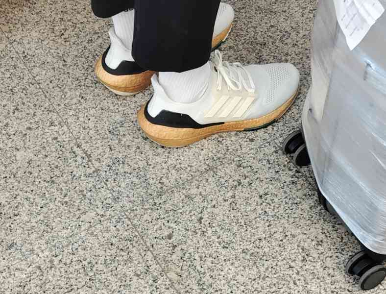 Personne portant une paire de baskets blanches