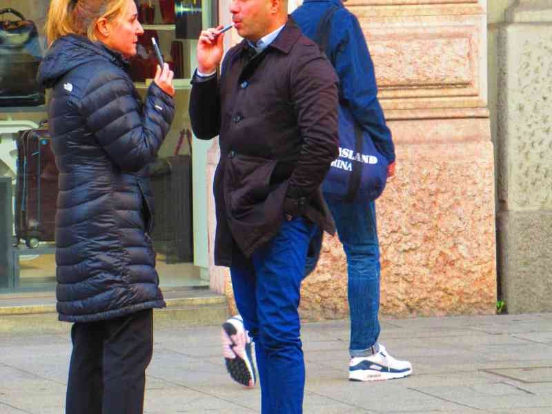 Deux personnes qui fument et discutent dans la rue photo gratuite