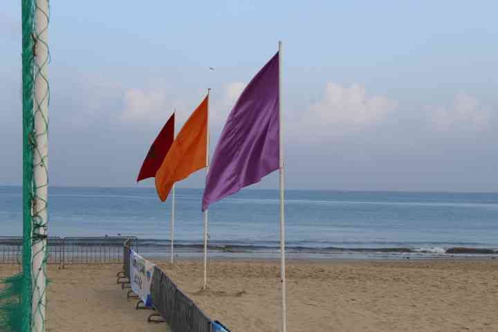 Trois drapeaux sur une plage avec vue sur l'océan photo grauite - Drei Flaggen an einem Strand mit Blick auf den Ozean, kostenloses Foto