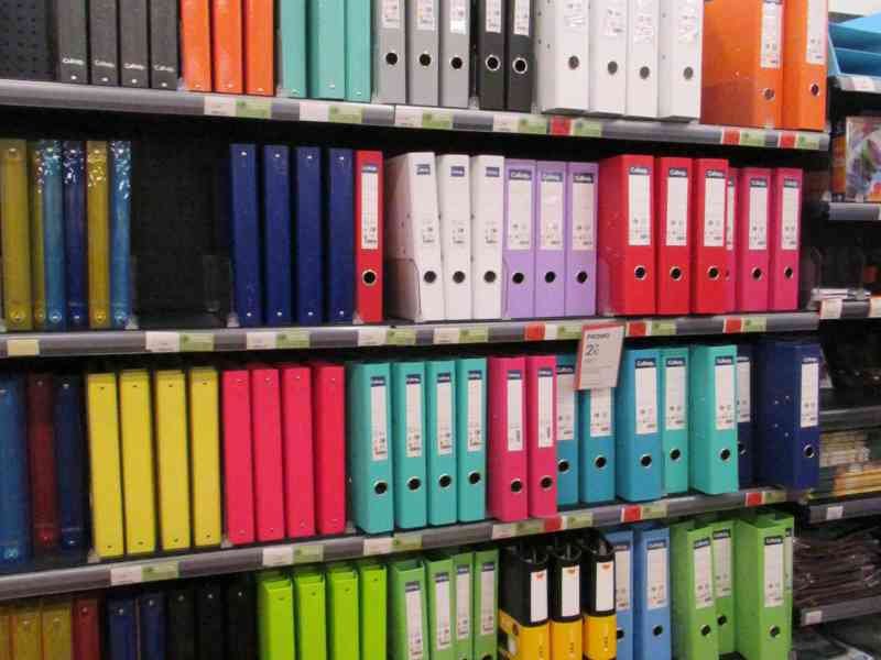 Alignement de classeurs à levier multicolores sur les étagères d'un magasin