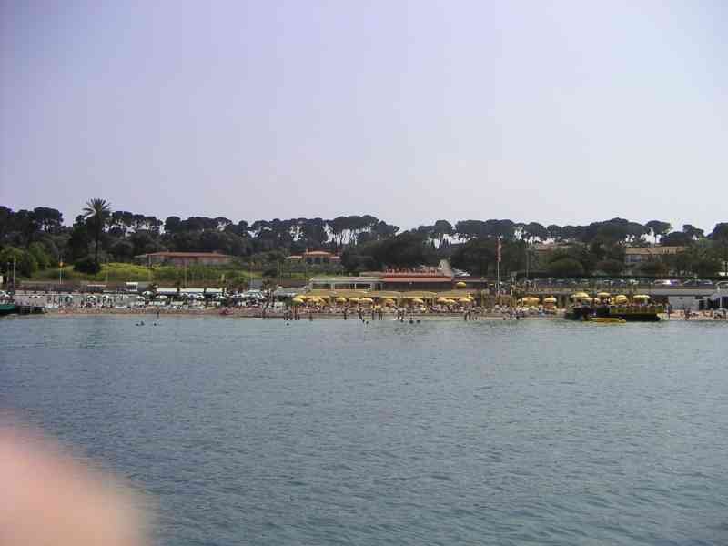 Une plage animée, des parasols jaunes sont visibles sur la plage, indiquant une activité balnéaire, photo gratuite