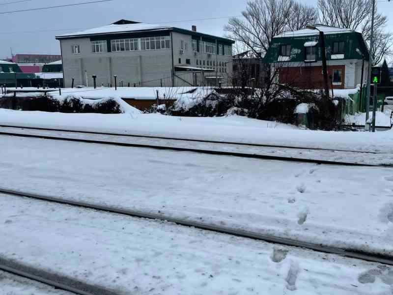 Voie de tramway recouverte de neige avec des bâtiment en arrière-plan photo gratuite - Straßenbahngleise mit Schnee bedeckt, mit Gebäuden im Hintergrund, kostenloses Foto