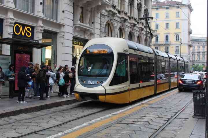 Tramway électrique en déplacement dans la ville de Milan, on observe des personnes devant le magasin OVS, prêt à embarquer, photo gratuite