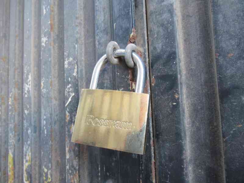 Un cadenas Bossram verrouillé, fixé à une porte de conteneur, photo gratuite