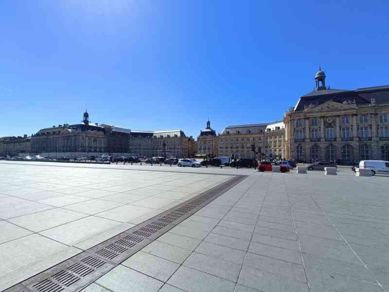 La place de la Bourse et le Miroir d'eau à Bordeaux, en France, des voitures devant les bâtiment, photo gratuite